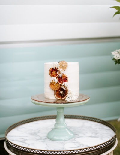 A white wedding cake with dried citrus