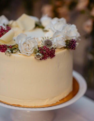 Wedding cake with white and red flowers.