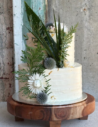 White wedding cake decorated with thistles, dried flowers and greenery